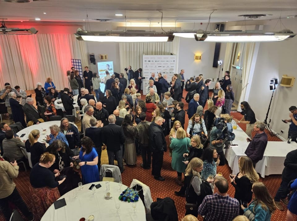 large group of people standing at a conference